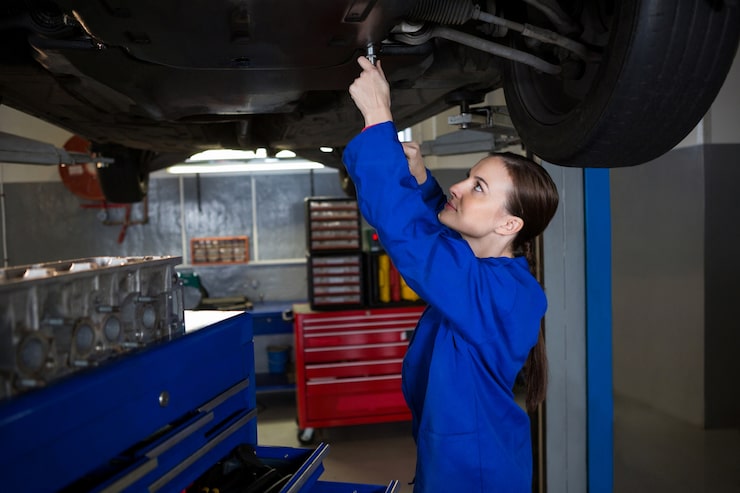 Car undercarriage suspended on workshop hoist