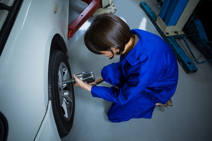 Mechanic measuring tyre tread depth