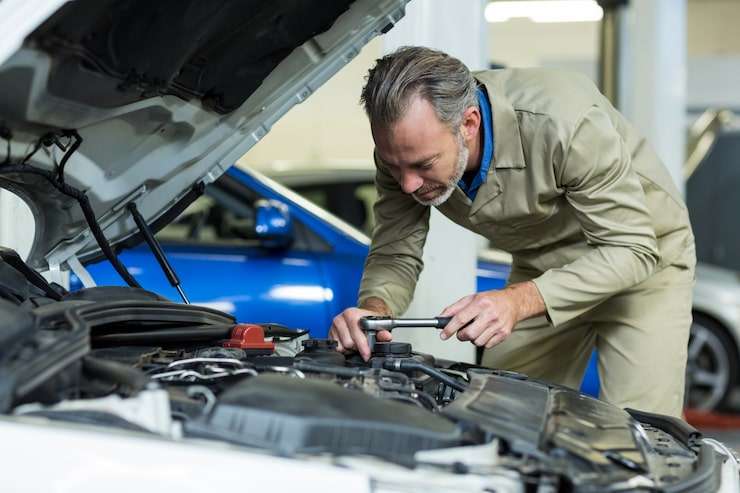 Experienced mechanic checking engine